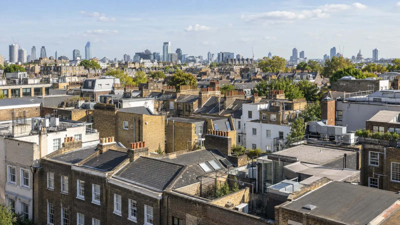 Rooftops of a British city, period terraces in the foreground and the skyline beyond